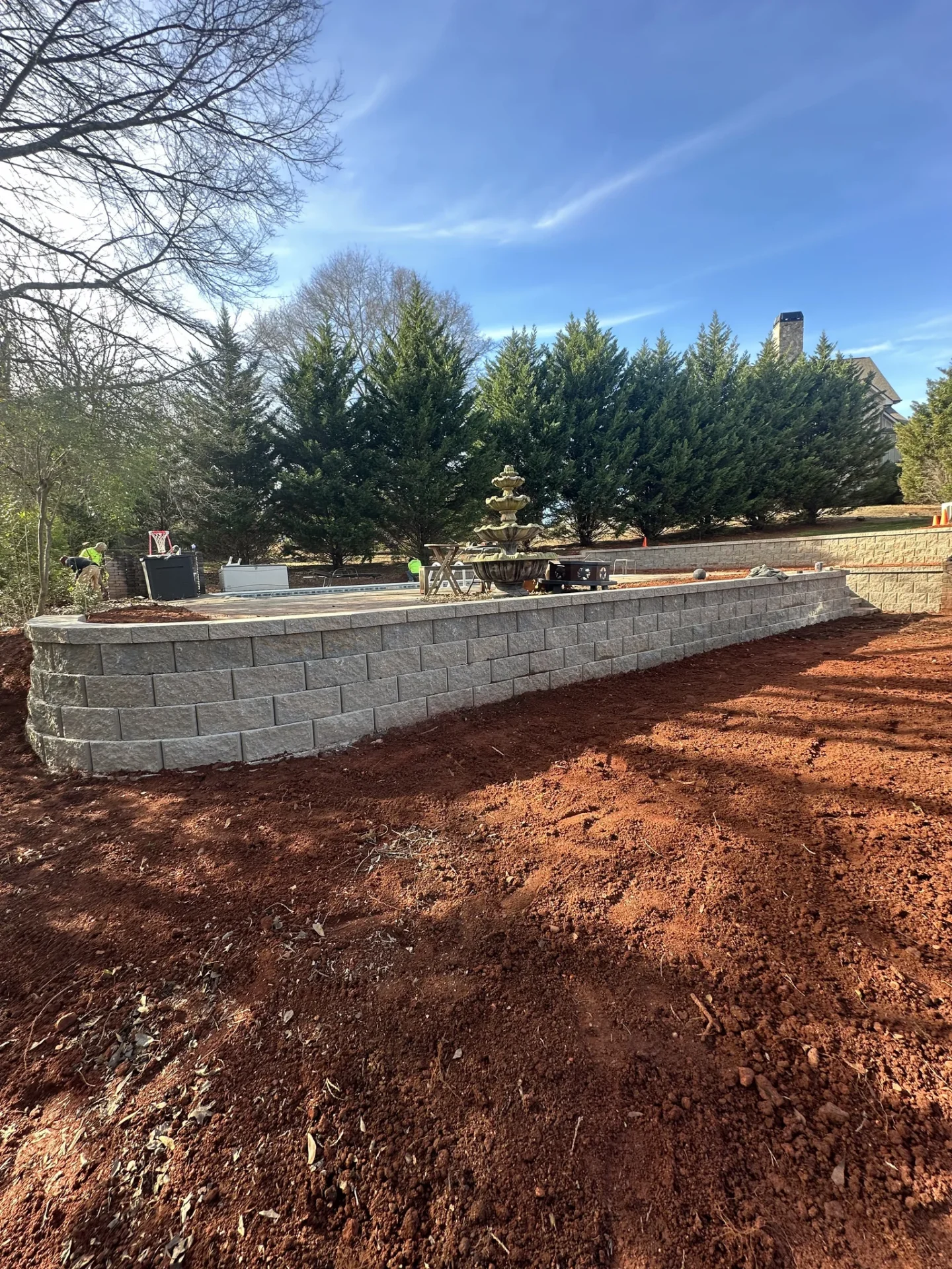 New gray block retaining wall around backyard patio