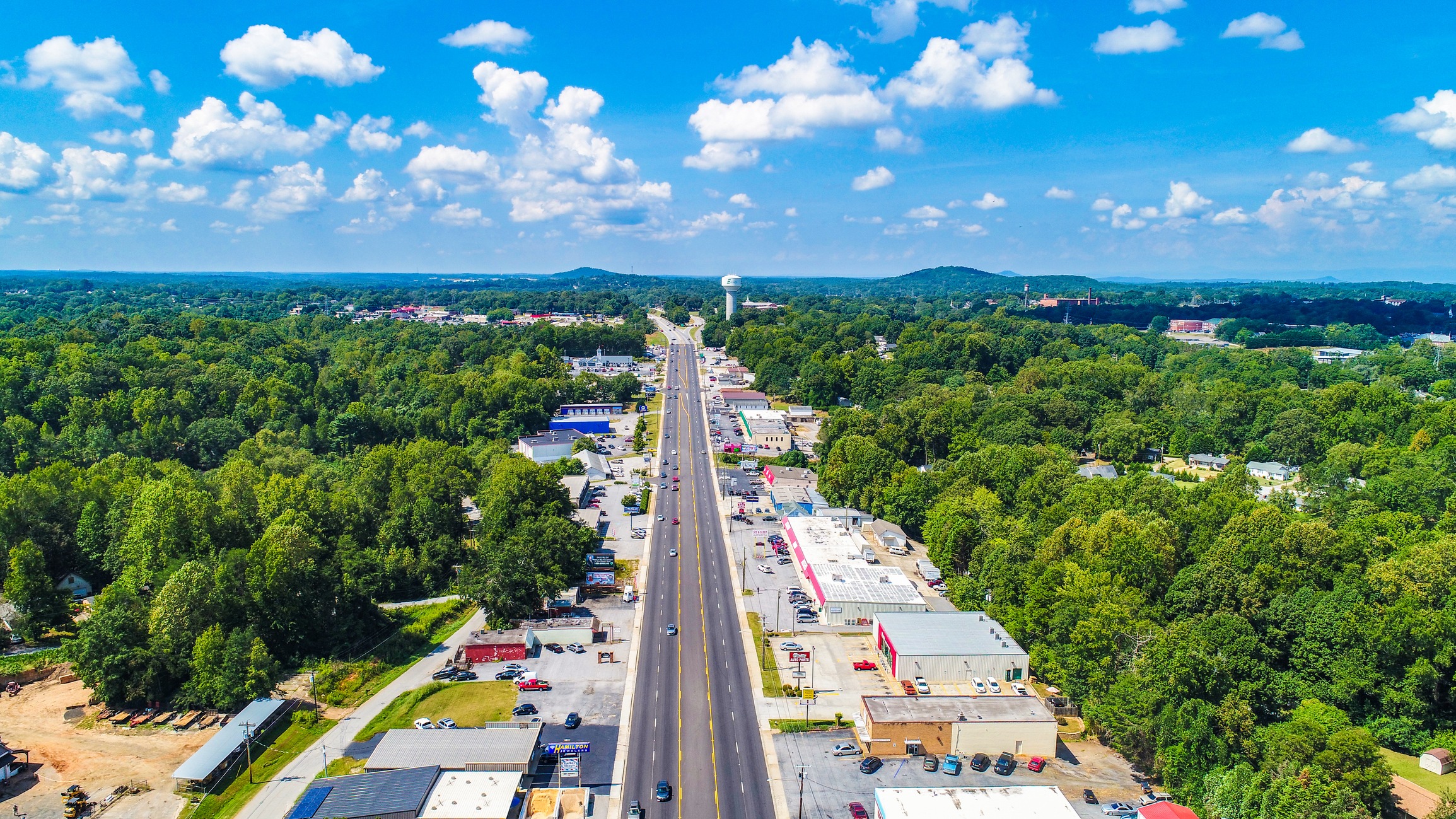 Aerial view of a highway through a green suburban town
