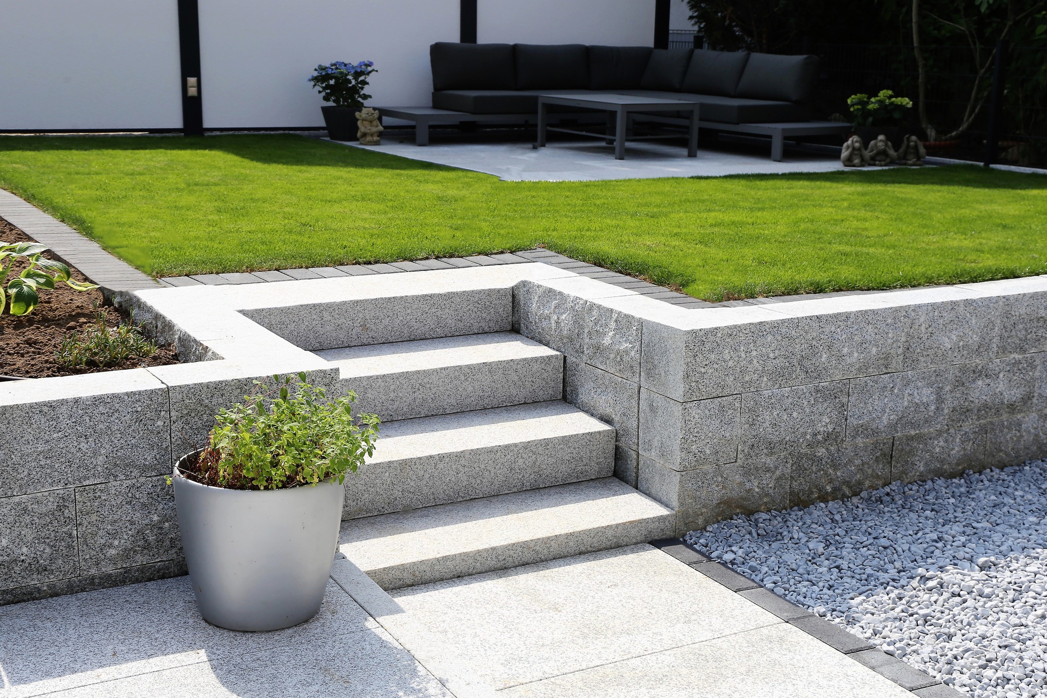 Modern landscaped patio with stone steps and green lawn