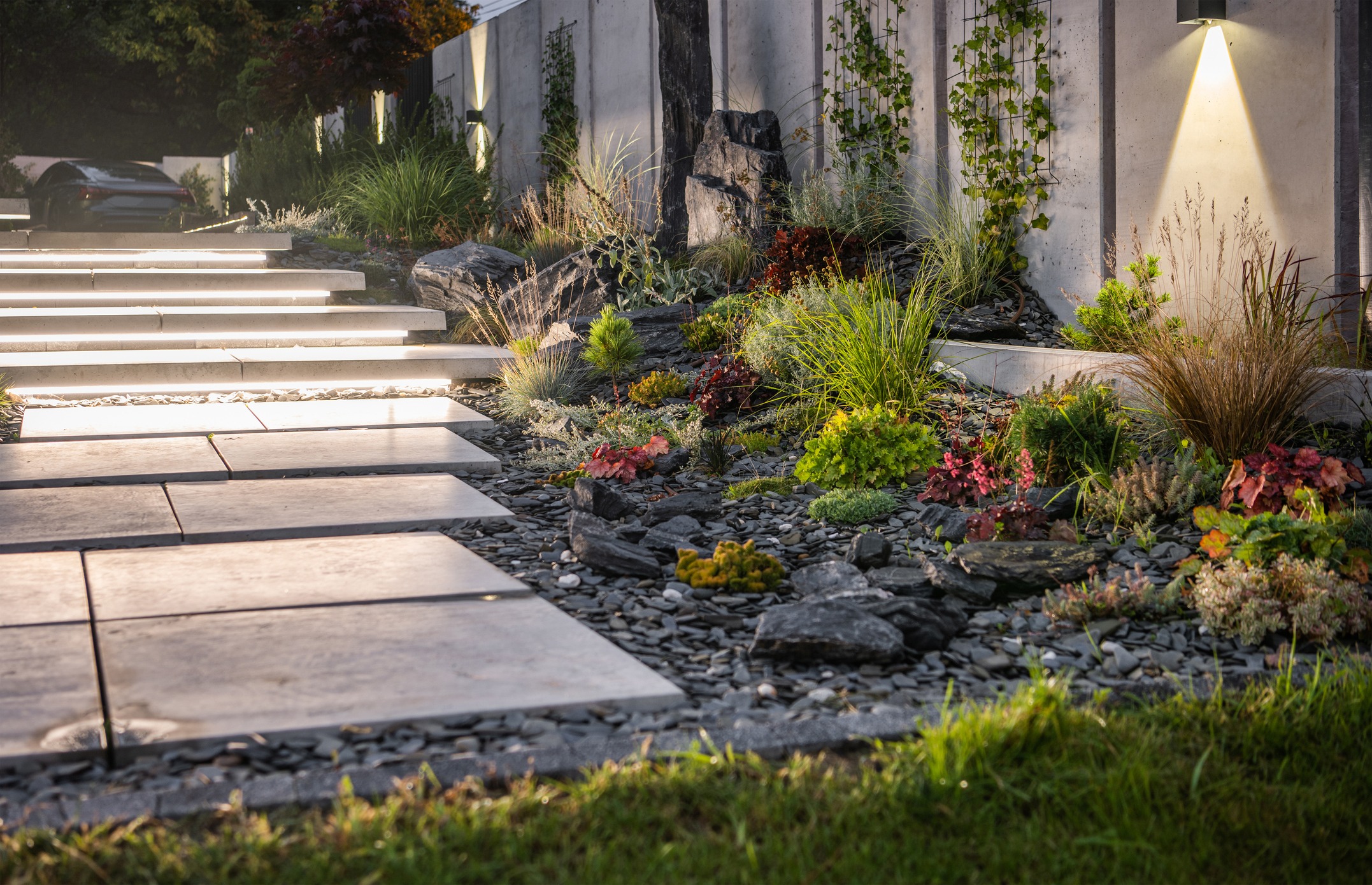 Illuminated stone steps beside a modern landscaped garden