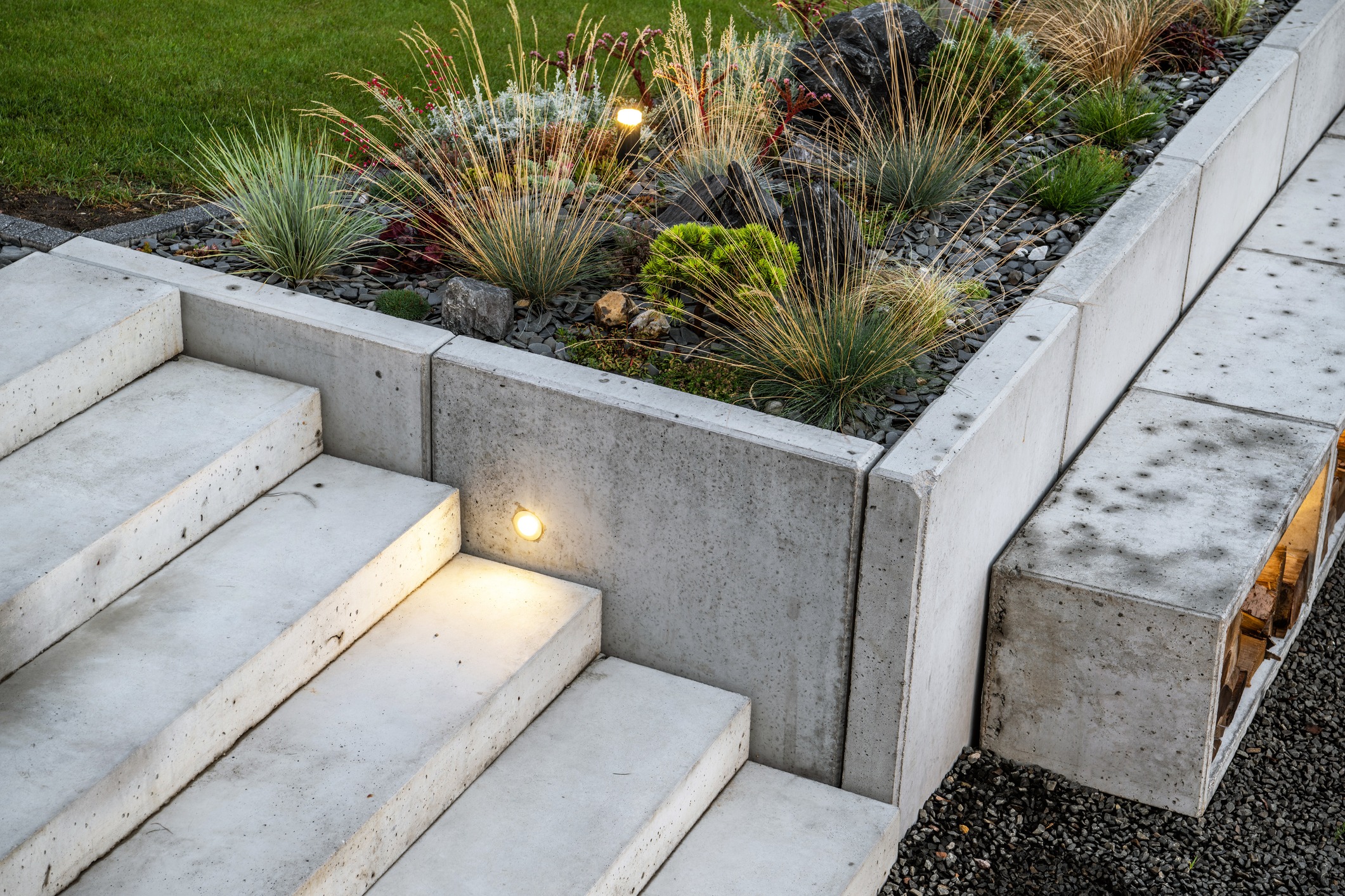 Illuminated concrete steps beside a landscaped ornamental grass garden
