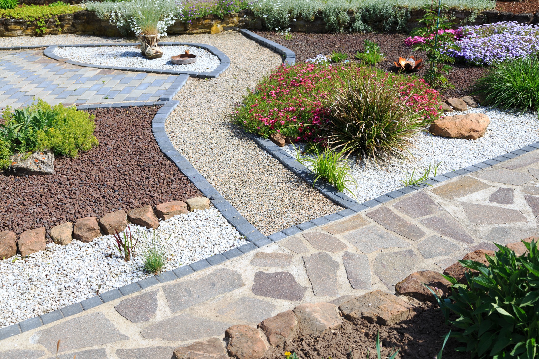 Curved gravel paths through colorful landscaped garden beds