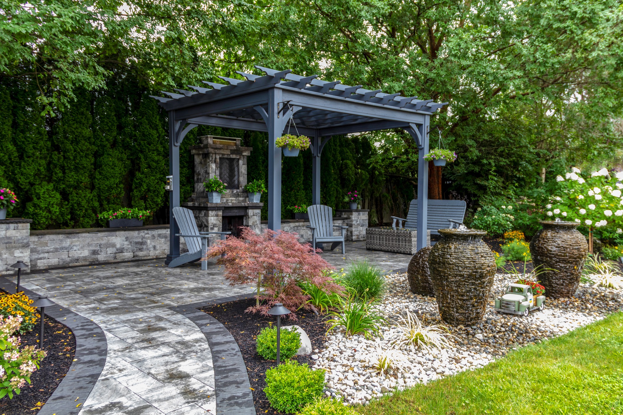 Pergola patio with fireplace, fountain, and landscaped garden