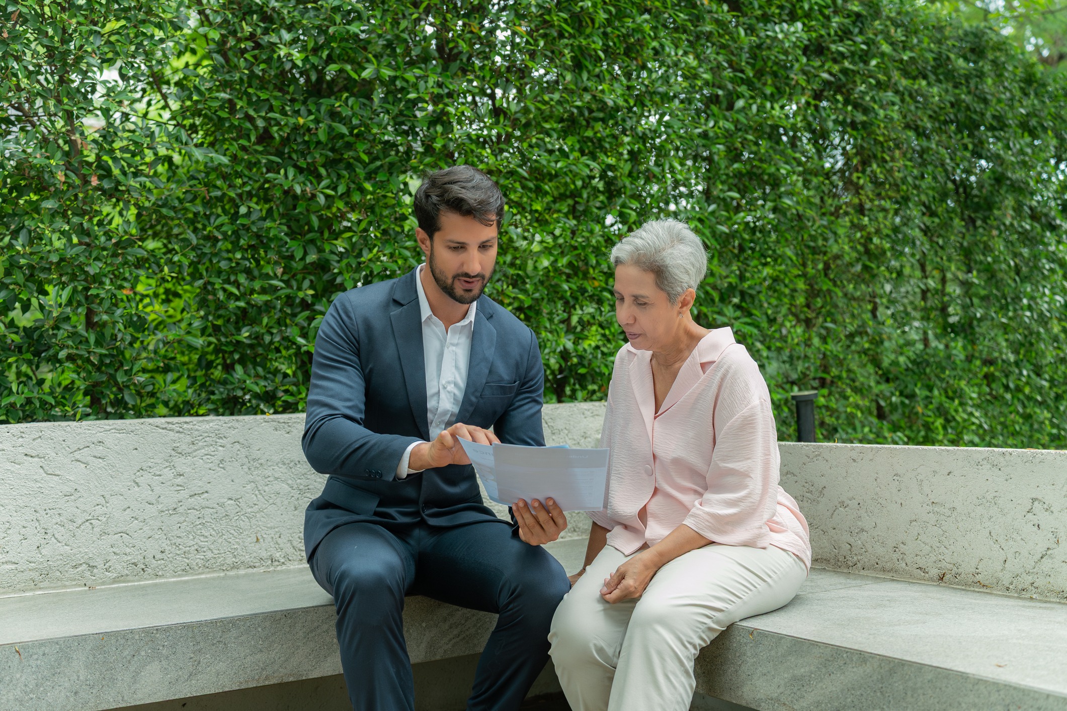Man and older woman review documents outdoors