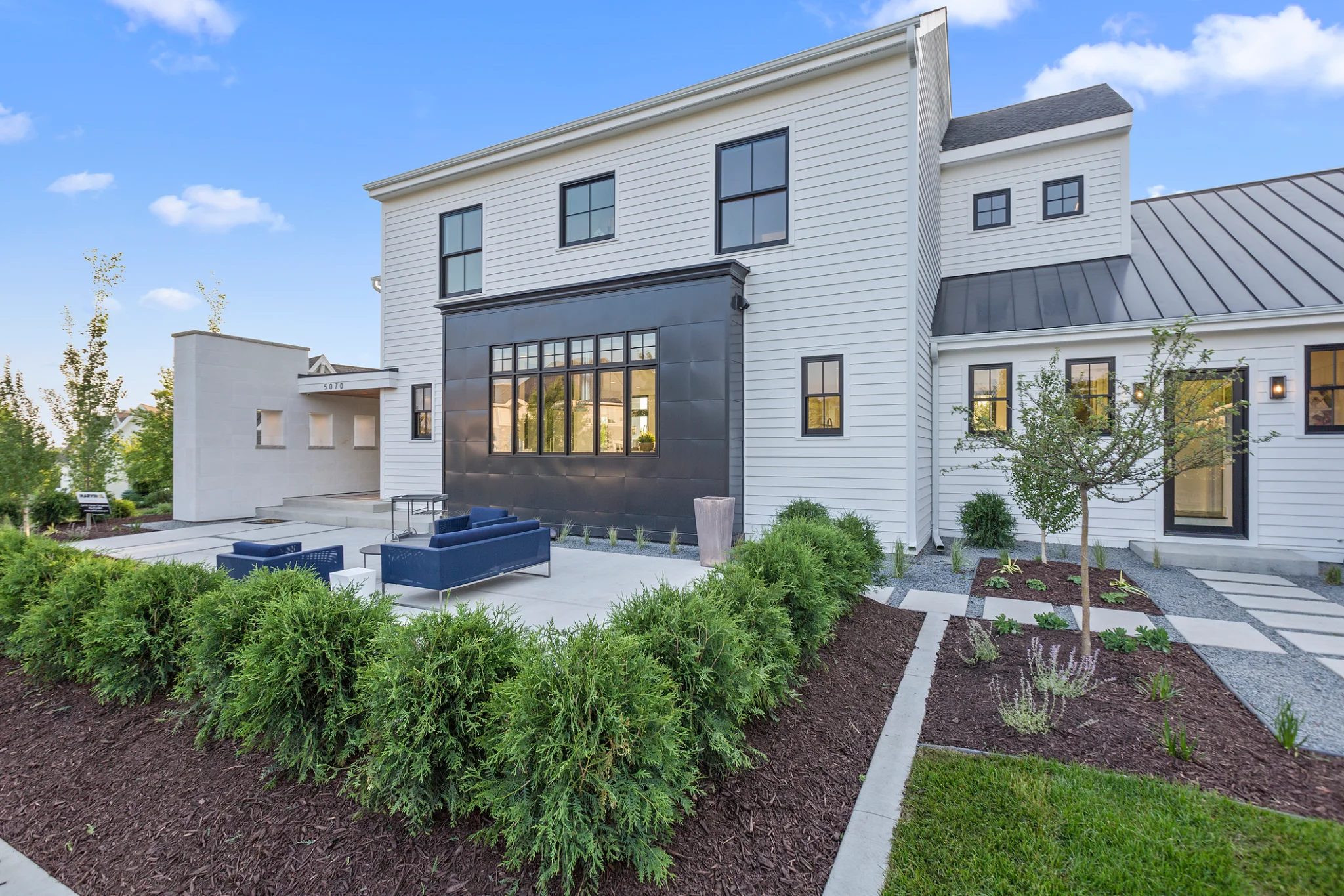 Modern white home with landscaped patio and black accents