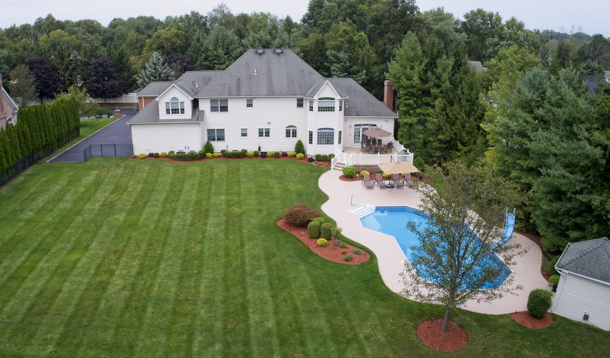 Aerial view of house, lawn, patio, and swimming pool