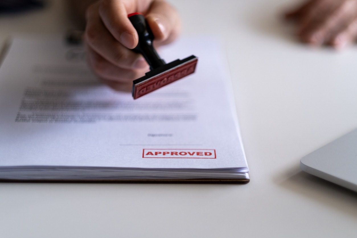 Hand stamping approved document on desk