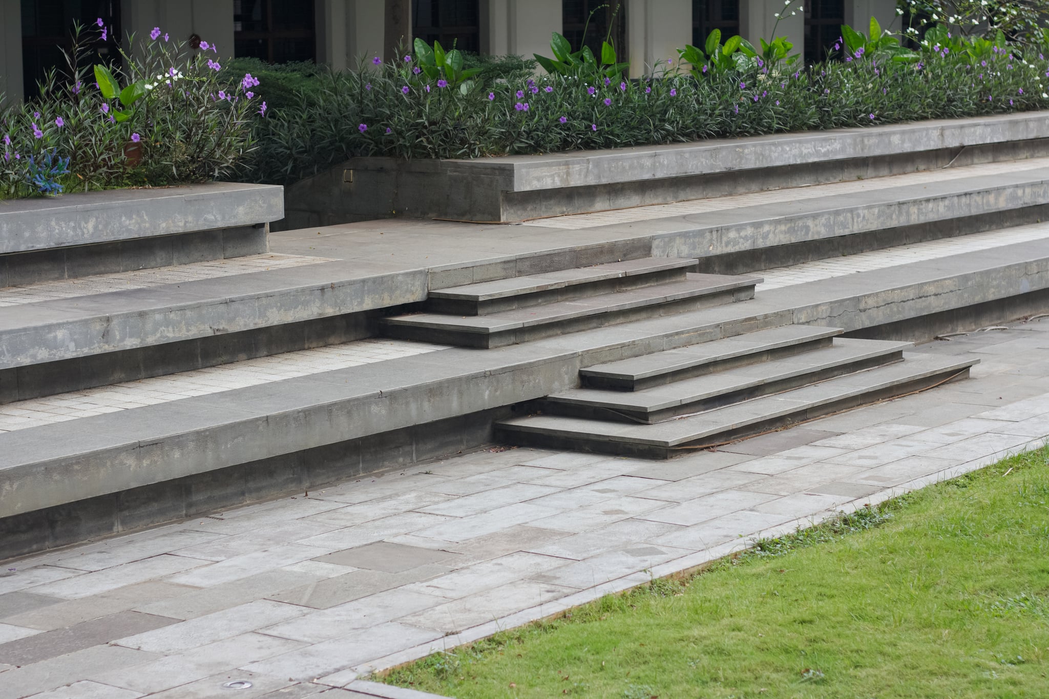 Tiered gray stone steps beside flowering garden beds